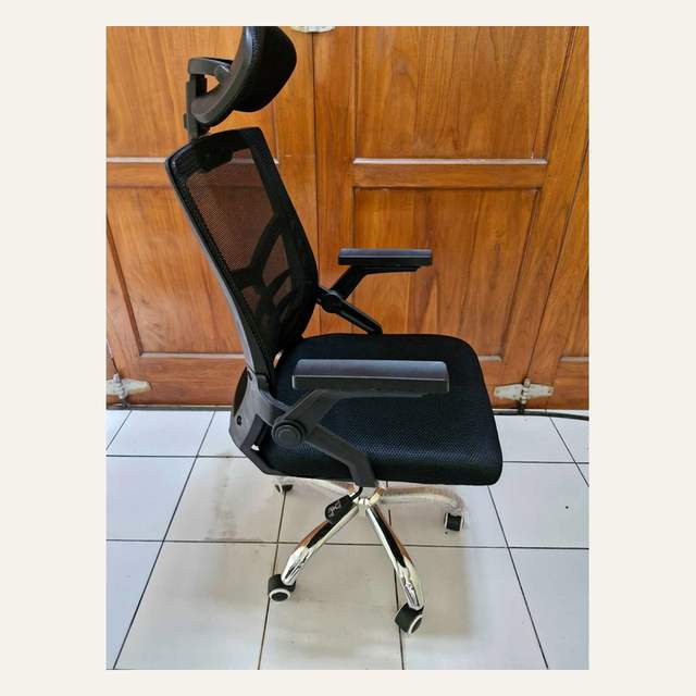 Kursi beroda hitam bersandaran kepala dari samping dengan armrest datar dan kaki lima cabang mengkilap.