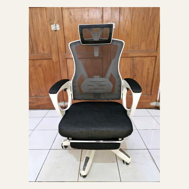 Kursi kantor tampak depan dengan sandaran jaring, bingkai putih, dudukan hitam, dan sandaran kaki.