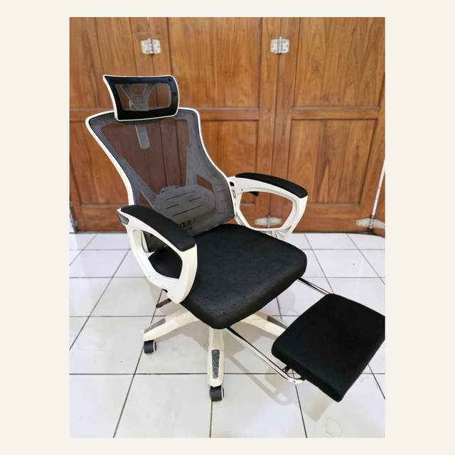 Kursi kantor rangka putih tampak serong dengan sandaran jaring hitam dan sandaran kaki terbuka.