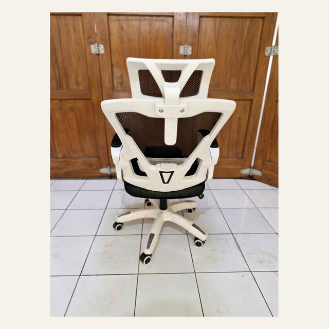 Kursi kantor tampak belakang dengan rangka putih bercabang, panel jaring, dan kaki beroda terbungkus plastik.