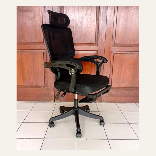 Kursi kantor hitam tampak serong memperlihatkan dua tuas di bawah dudukan dan panel sandaran kaki.