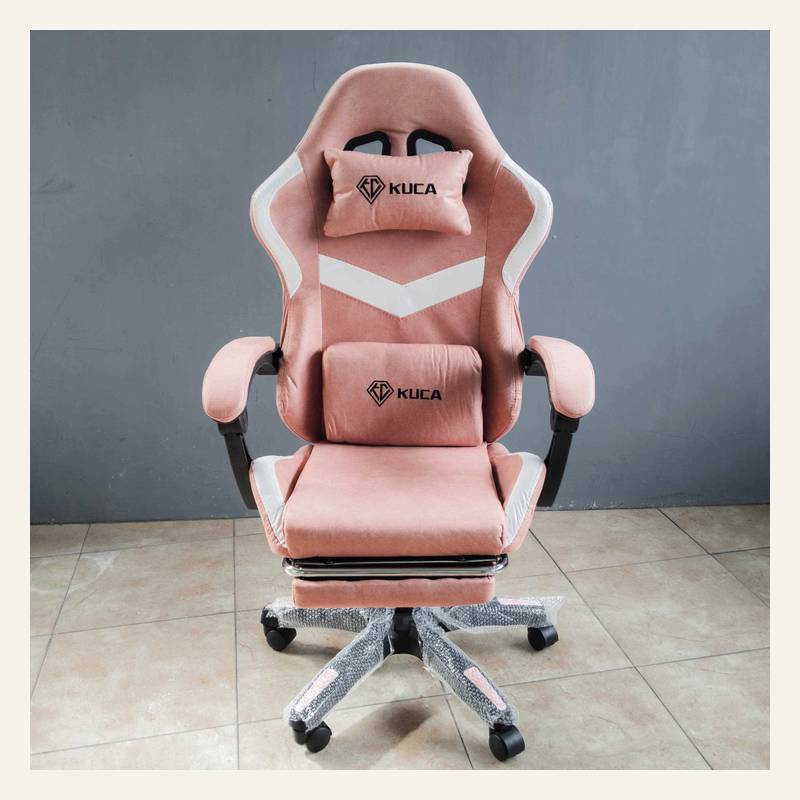 Kursi gaming merah muda tampak depan dengan dua bantal bertuliskan KUCA dan sandaran kaki terbuka.