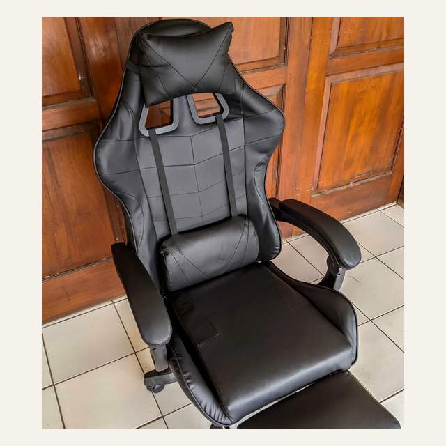 Kursi hitam polos difoto dari atas serong memperlihatkan sandaran, bantal, dan dudukan.