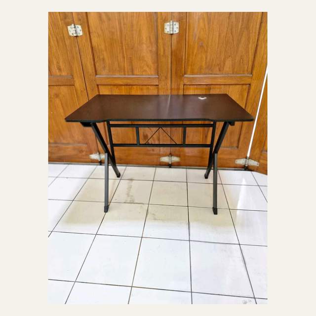 Meja bidang cokelat tua bertepi berlekuk dengan lubang kabel dan rangka pipa hitam berkaki miring.