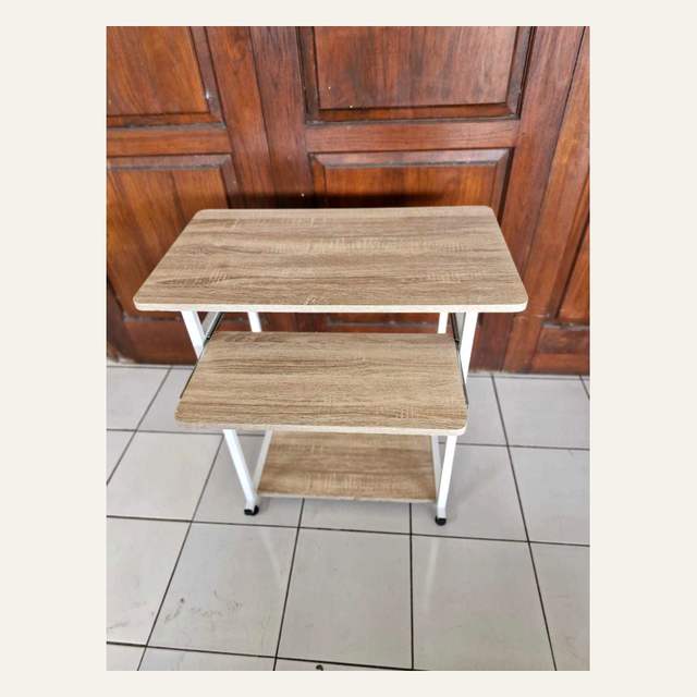 Rak tiga papan motif kayu terang berangka putih difoto menyerong dari arah atas.
