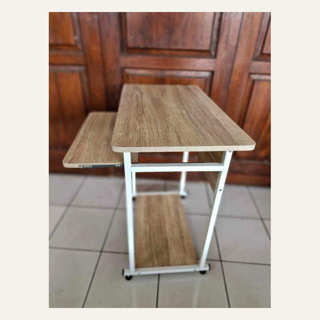 Rak papan motif kayu terang berangka putih dengan roda difoto dari sisi samping.