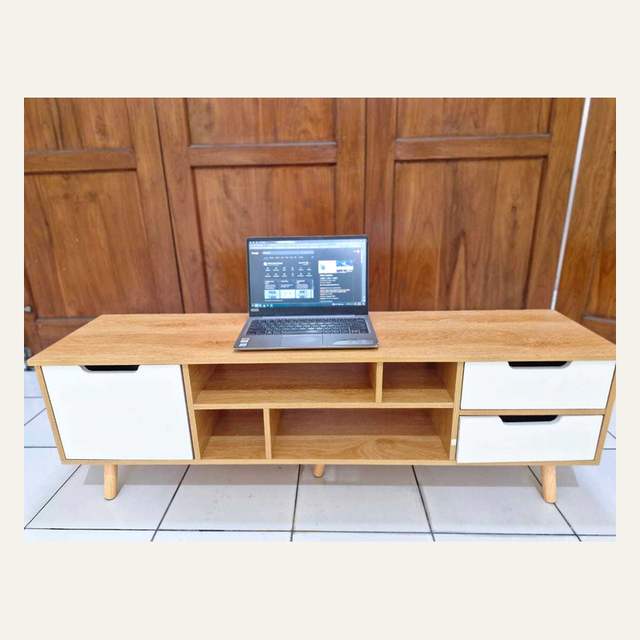 Rak motif kayu terang berpintu dan berlaci putih dengan laptop terbuka di atasnya.