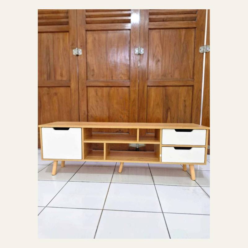 Rak rendah motif kayu terang dengan satu pintu dan dua laci putih di lantai keramik putih.