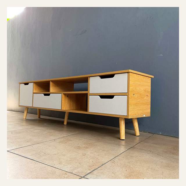 Rak tv motif kayu terang dengan pintu dan laci putih difoto menyerong dari sisi kanan.