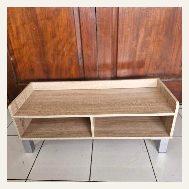 Rak rendah motif kayu terang dengan dua ruang terbuka dan kaki perak difoto menyerong.